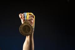 male-athlete-holding-medal